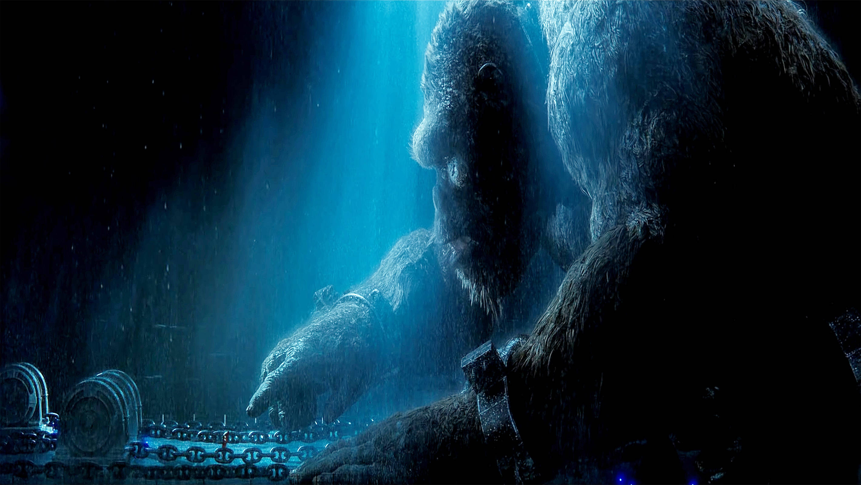 Godzilla Vs Kong 2021 桌布 壁紙 — 一隻巨大的大猩猩被鎖鏈拴著，坐在深藍色深淵的水下，光線穿透水面照射下來。