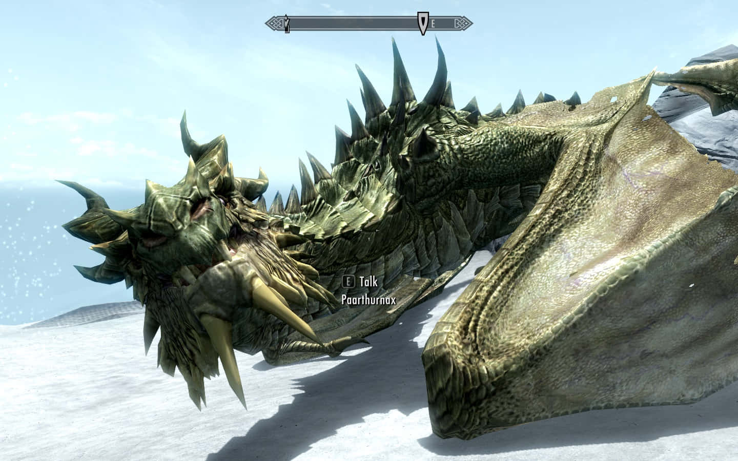 Skyrim Paarthurnax 桌布 壁紙 — 一隻巨大的綠色鱗片龍，背上有尖刺和金色角，在明亮的天空下躺在雪地上休息。