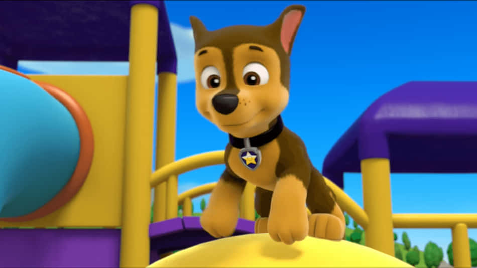 Chase Paw Patrol 桌布 壁紙 — 一隻帶有星星徽章的快樂卡通小狗坐在色彩繽紛的遊樂場結構上，背景是明亮的藍天。