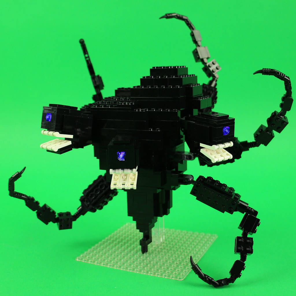 Wither 桌布 壁紙 — 一隻帶有發光藍色眼睛和白色尖牙的威脅性黑色LEGO蜘蛛，站在綠色底板上，背景是鮮豔的綠色。