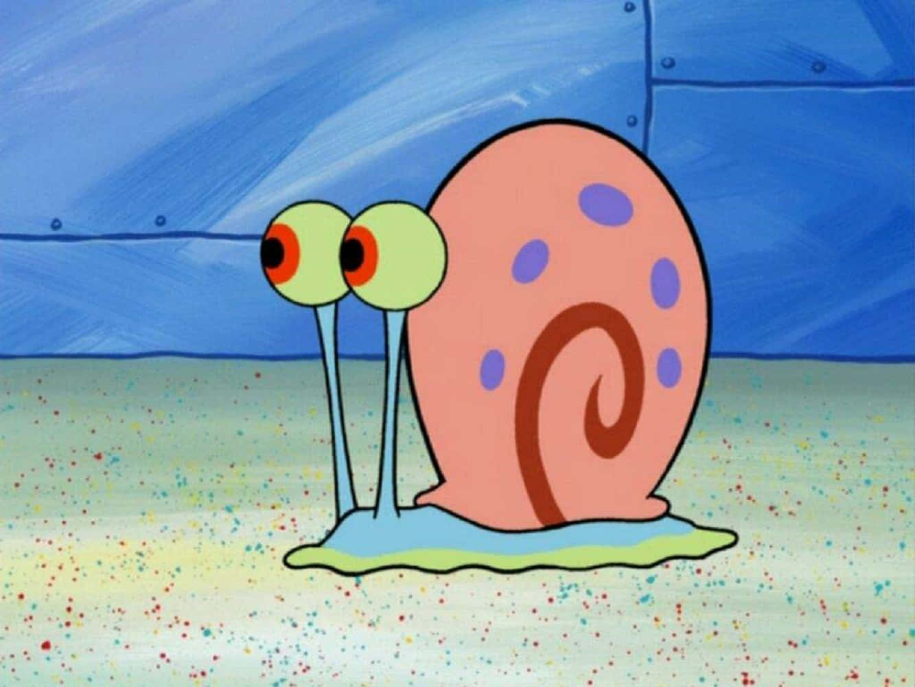 Gary The Snail 桌布 壁紙 — 一隻帶有粉紅色殼和紫色斑點的卡通蝸牛在藍色瓷磚牆下的斑點沙地上爬行。