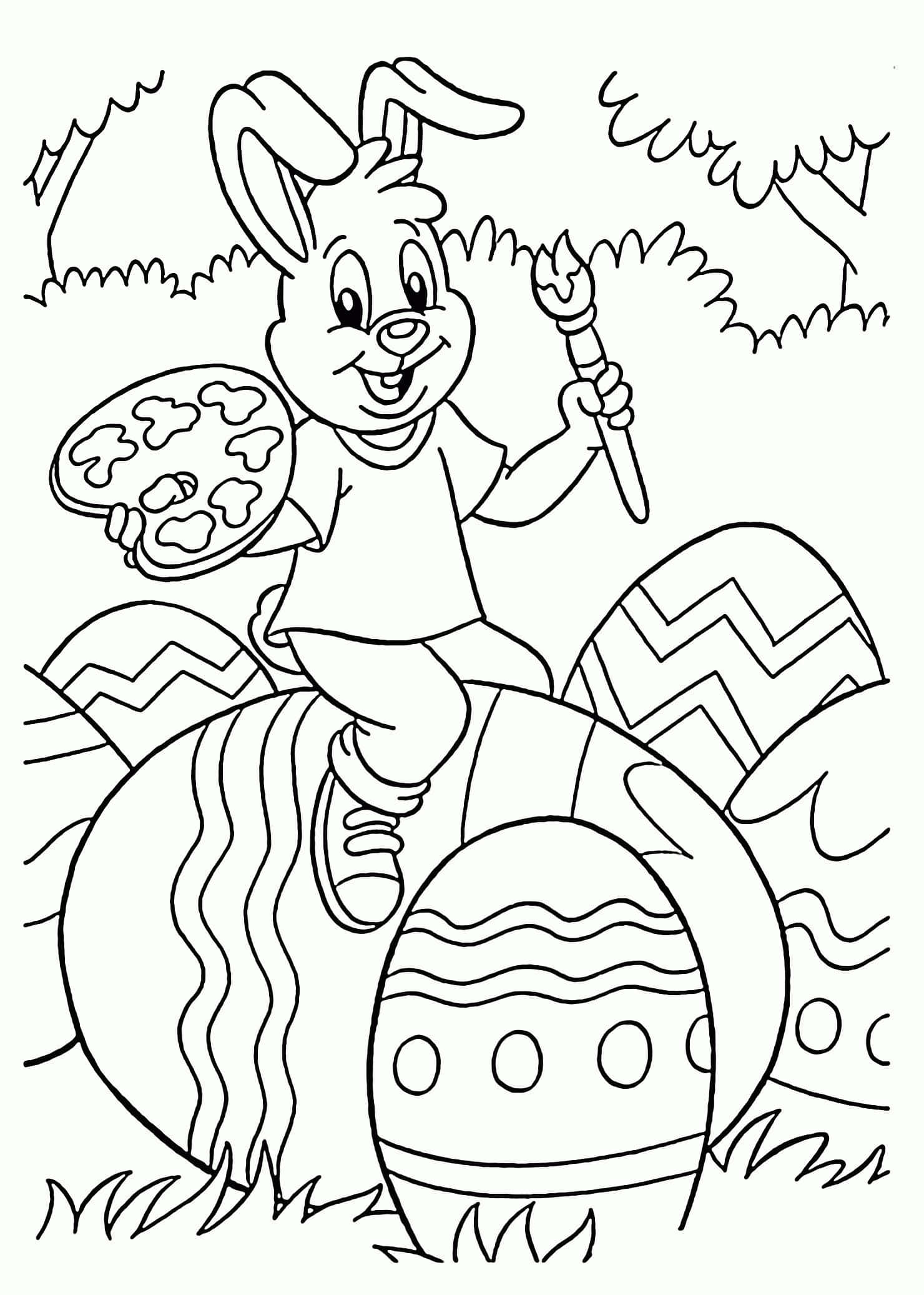 Easter Bunny 桌布 壁紙 — 一隻快樂的卡通兔子拿著畫筆和調色板，坐在草地上裝飾好的復活節彩蛋上。