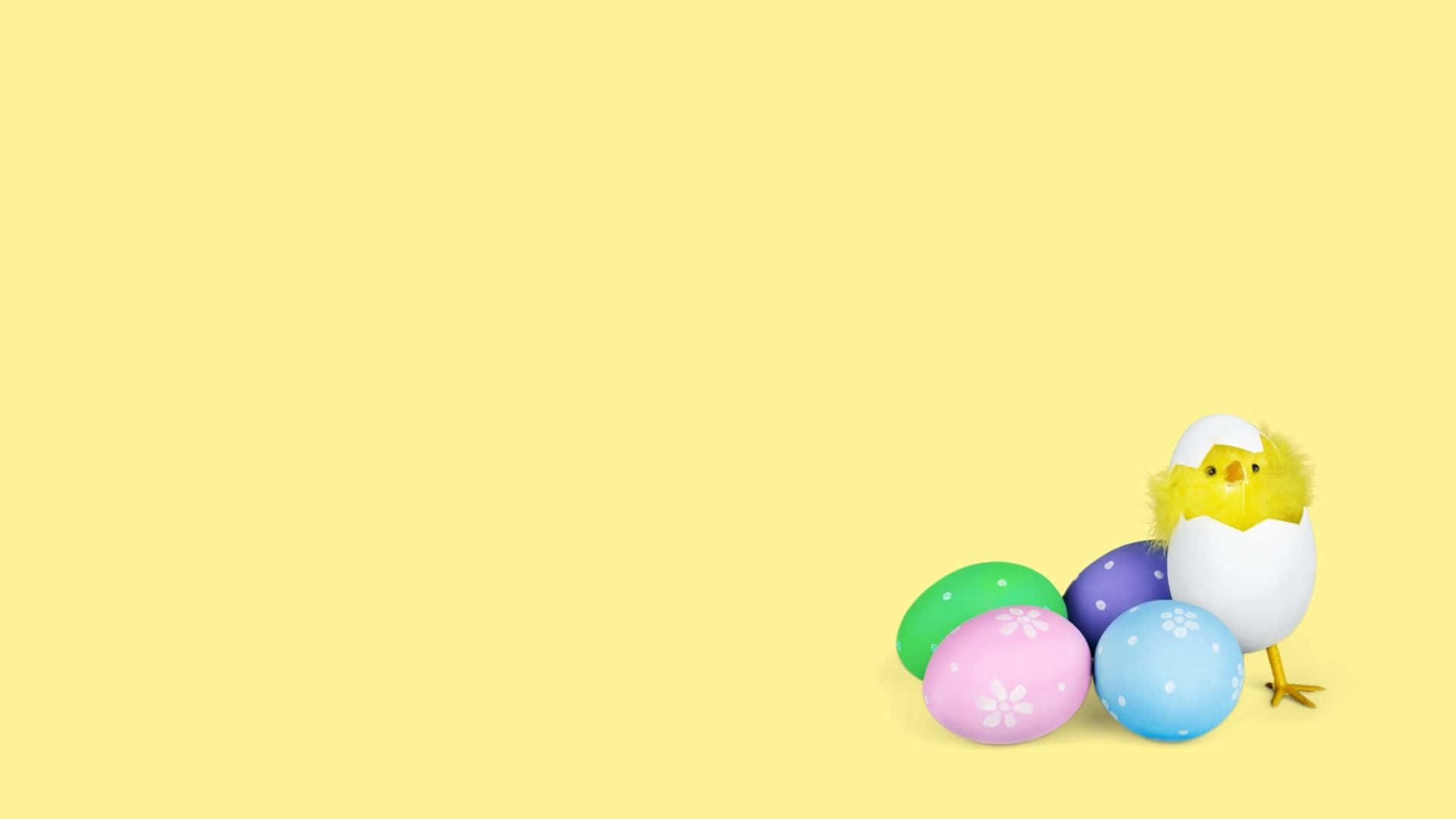 Easter Egg 桌布 壁紙 — 一隻快樂的黃色小雞從裂開的蛋中出現，旁邊是色彩繽紛、帶有圖案的復活節蛋，背景是柔和的黃色。