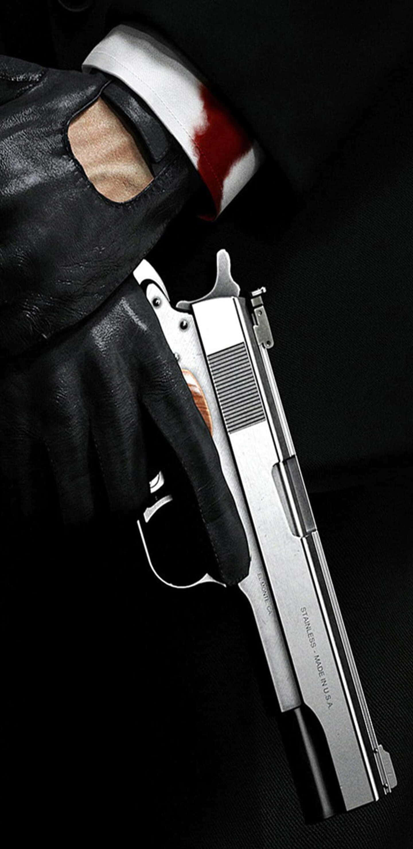 Pixel 3xl Hitman 桌布 壁紙 — 一隻戴手套的手握著銀色手槍，背景為黑色，可見沾有血跡的白色袖口。