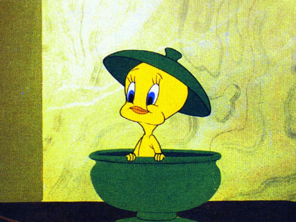 Tweety Bird 桌布 壁紙 — 一隻戴著綠色帽子的黃色卡通小雞坐在一個綠色碗裡，背景是帶紋理的黃色。