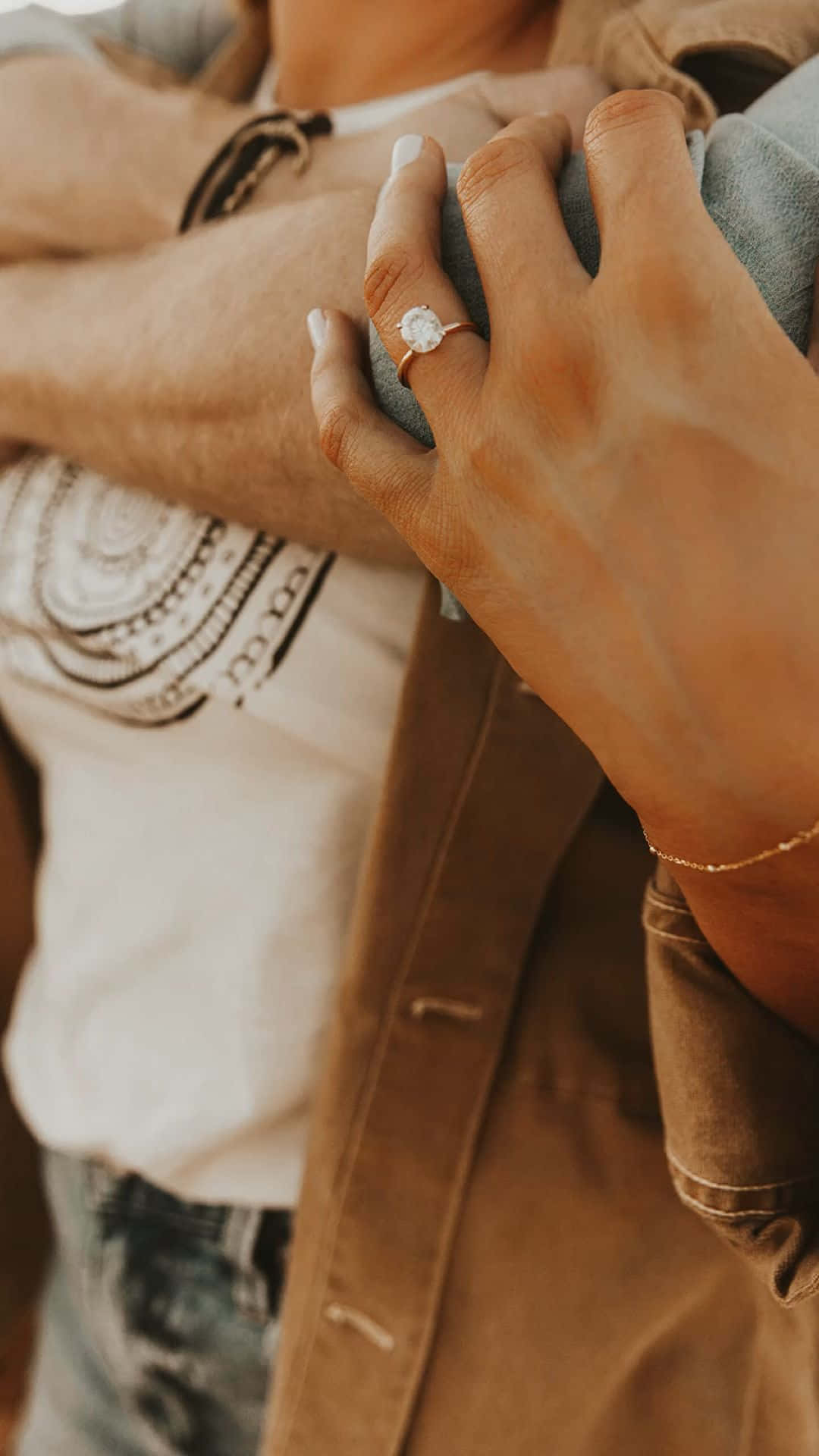 engagement 桌布 壁紙 — 一隻戴著閃爍單鑽訂婚戒指的手，正溫暖地擁抱著某人的特寫。