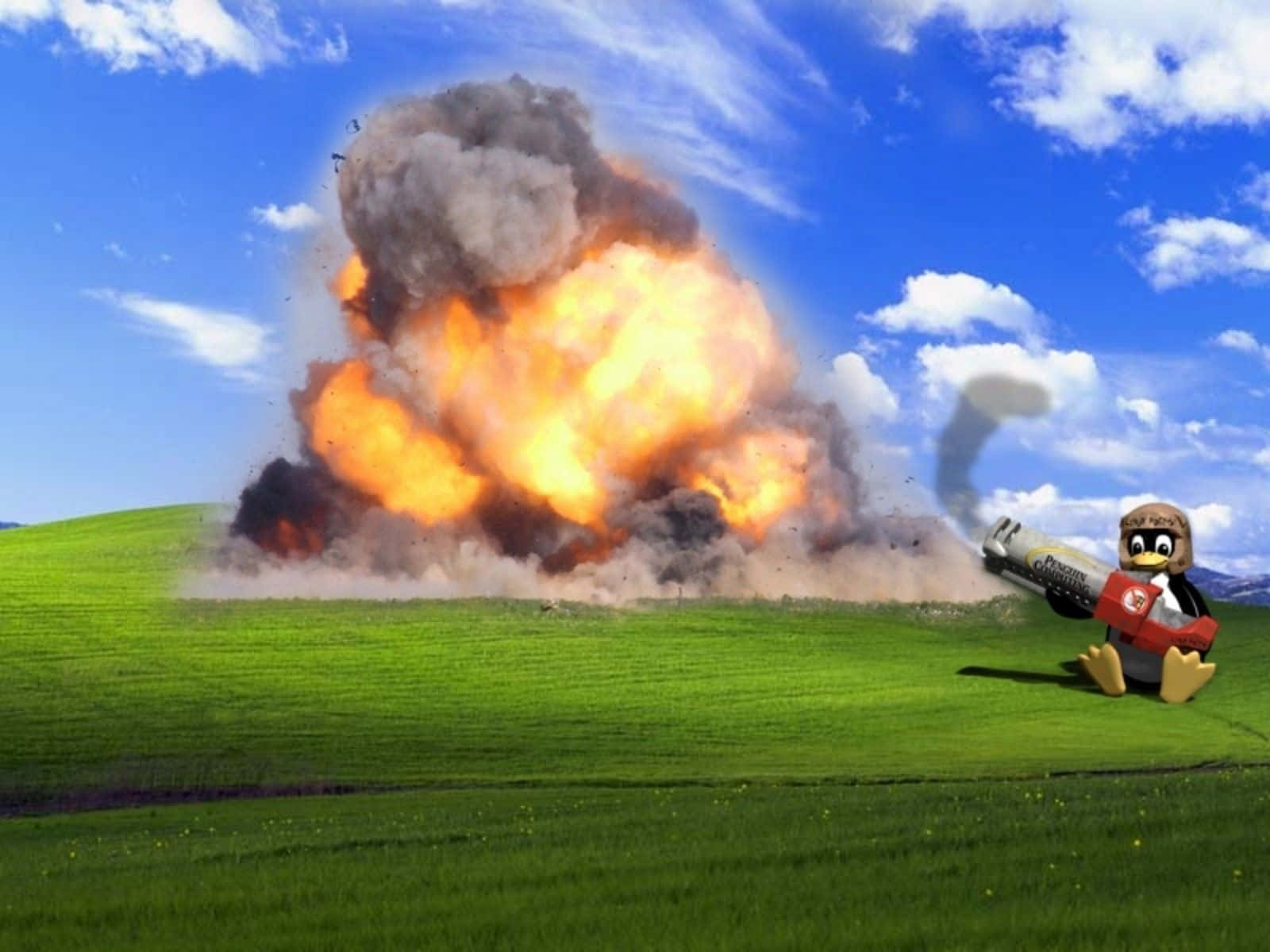 Windows XP 桌布 壁紙 — 一隻戴頭盔的卡通企鵝發射火箭炮，在藍天白雲下的綠色山丘上造成巨大爆炸。