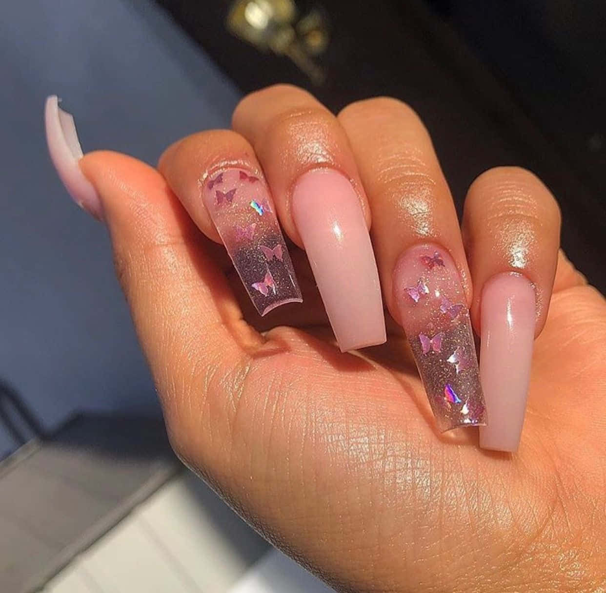 Pink Nails 桌布 壁紙 — 一隻手，帶有長方形棺材指甲，上面有粉紅色蝴蝶亮片設計和柔和粉紅色漸層。