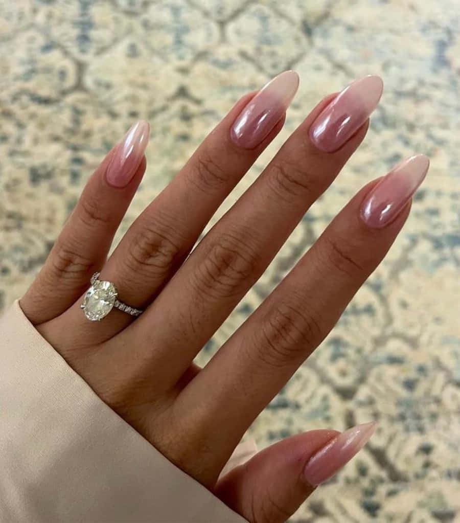 Pink Nail Art 桌布 壁紙 — 一隻手，手指上有長長的粉紅色漸變指甲和無名指上戴著一個大的橢圓形鑽石戒指。