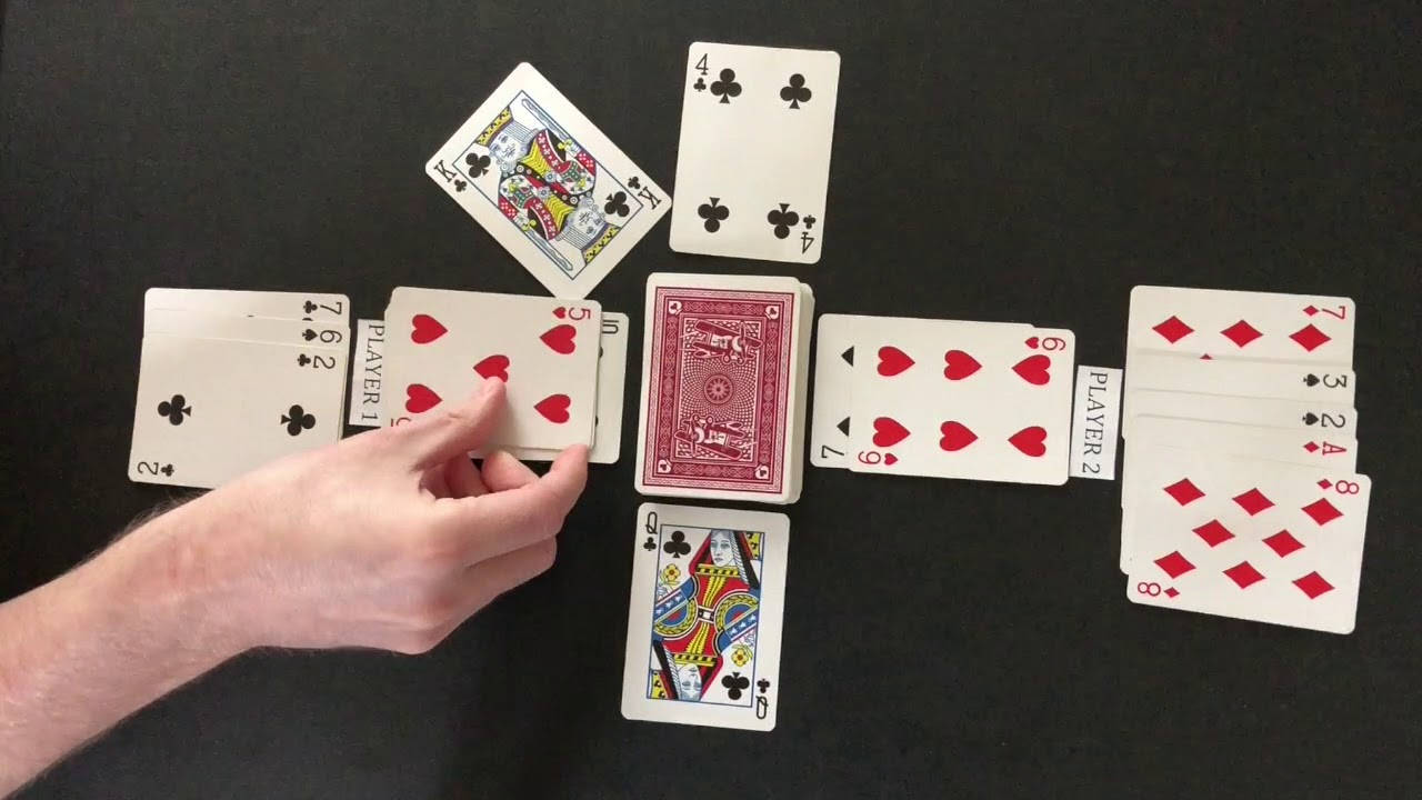 鑽石 桌布 壁紙 — 一隻手伸向一張紅色背面的撲克牌，周圍散落著面朝上的撲克牌，放在黑色表面上。