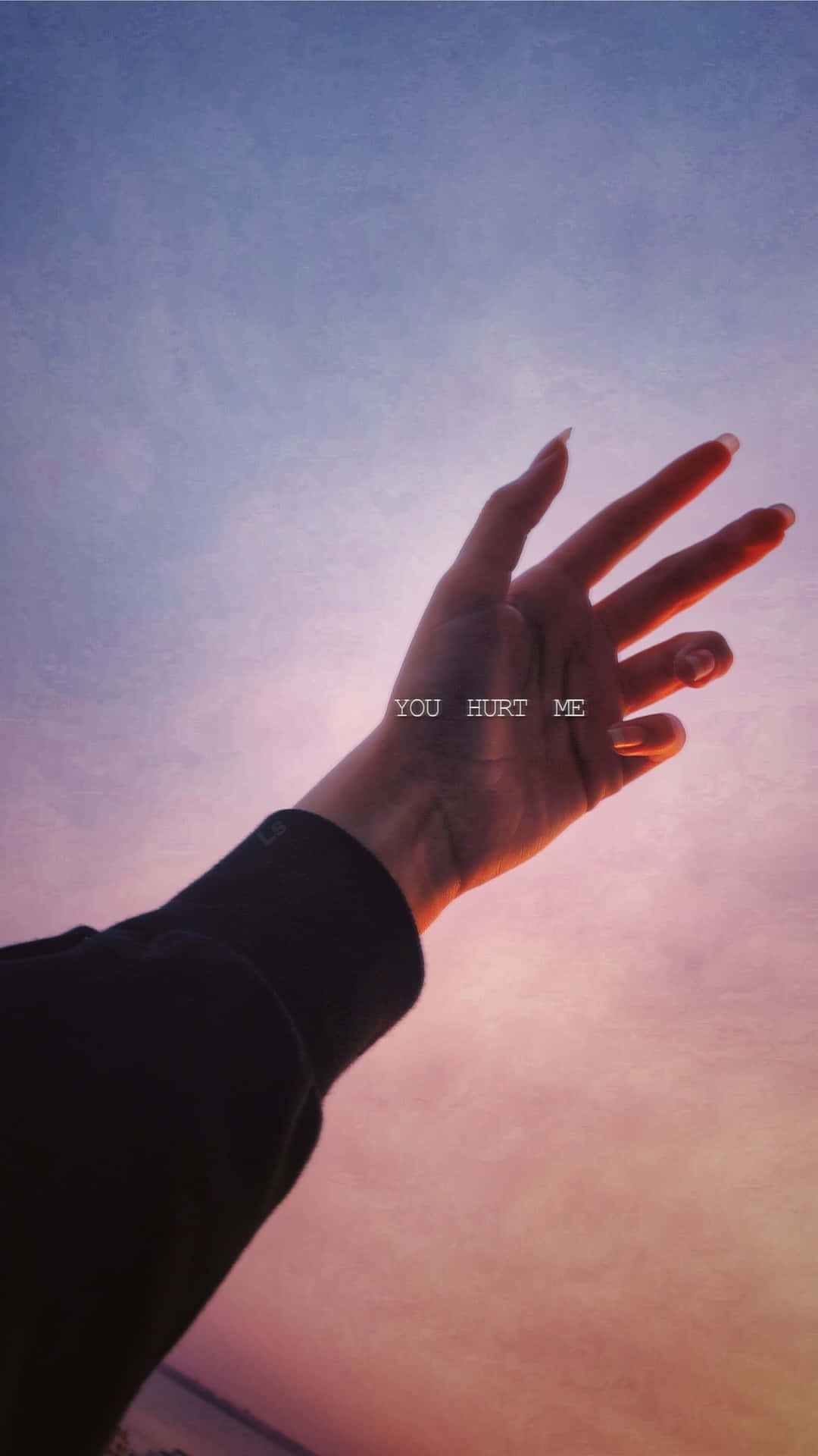 一隻手伸向紫色和粉紅色的日落天空，上面有文字 you hurt me。 — 烏賈因 馬哈卡爾 壁紙