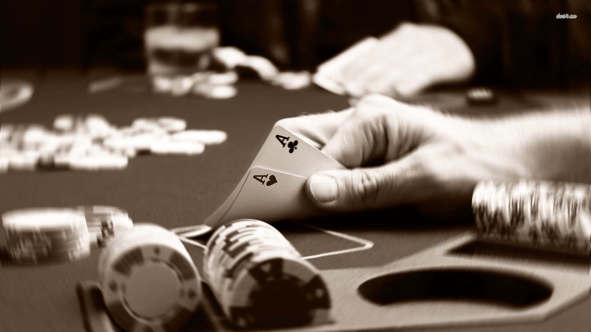 Poker 桌布 壁紙 — 一隻手在充滿戲劇性棕褐色調的撲克桌上，抓著兩張Ace，周圍堆滿了籌碼。