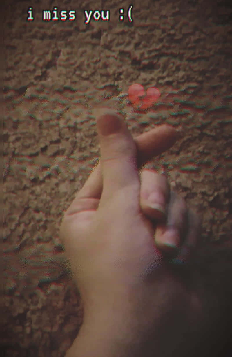 Broken Heart Aesthetics 桌布 壁紙 — 一隻手在帶有紋理的牆前做出心形手勢，牆上有一個褪色的紅色心形和文字 i miss you :(
