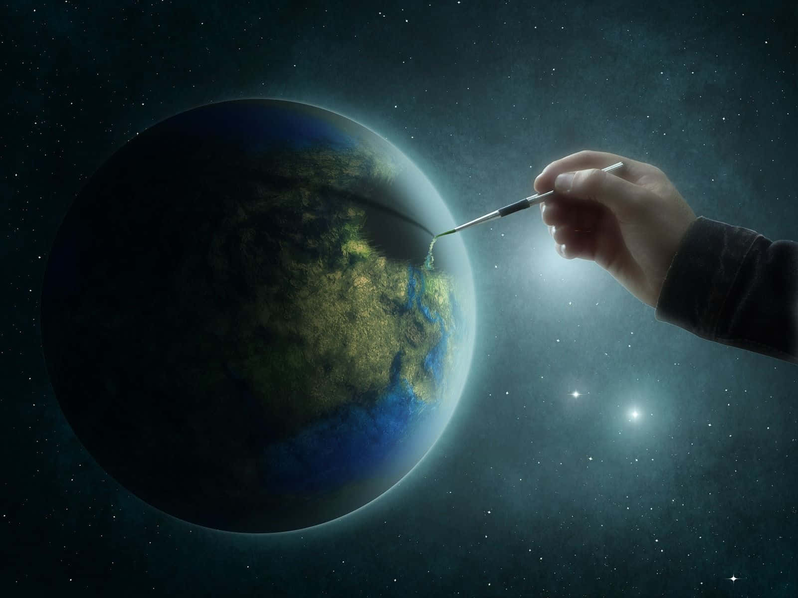 World 桌布 壁紙 — 一隻手在星空宇宙背景下，將發光的綠色大陸畫到一顆行星上。