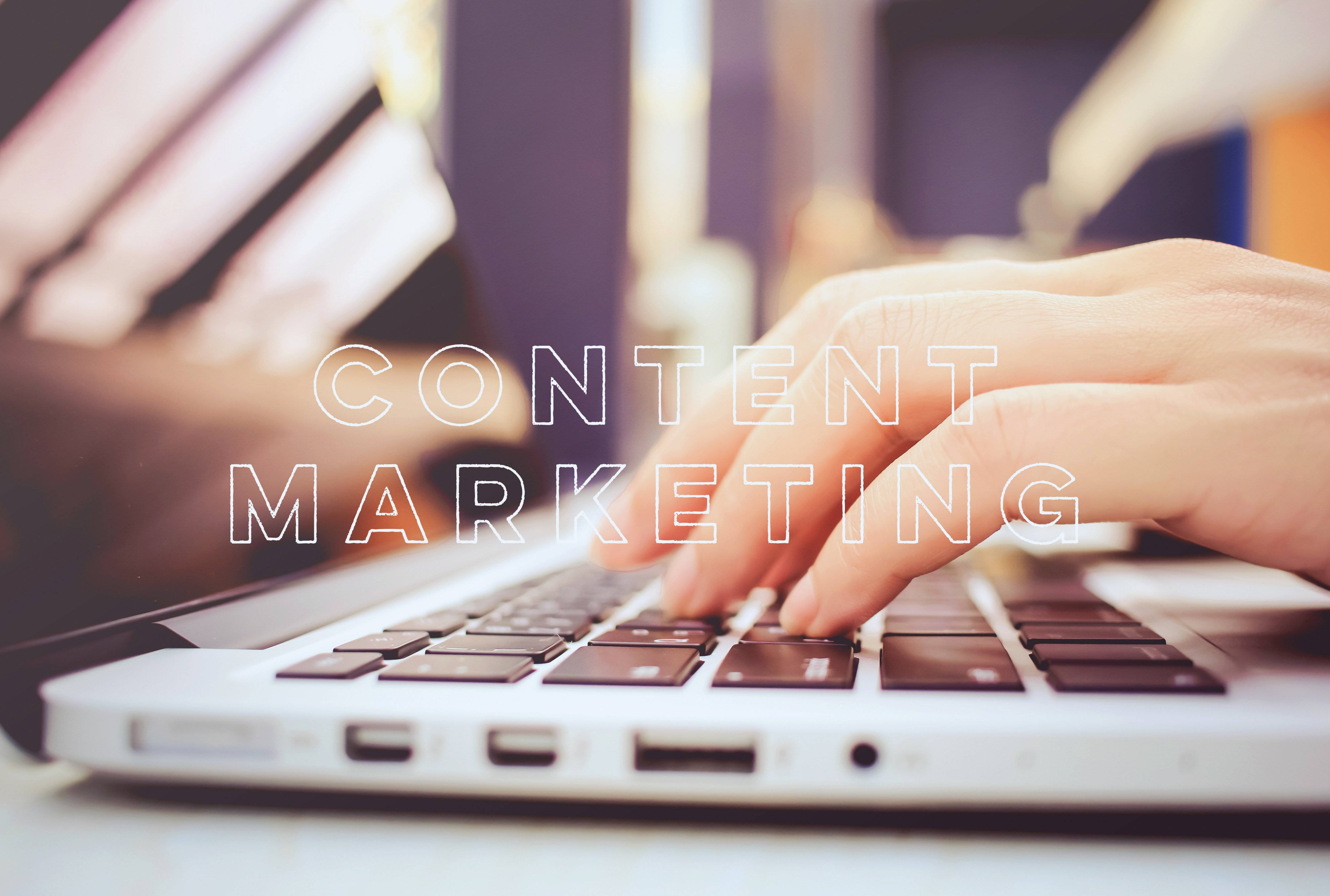MacBook 動態圖片 桌布 壁紙 — 一隻手在筆記型電腦鍵盤上打字，帶有「CONTENT MARKETING」文字疊加，背景是柔和模糊的辦公室環境。