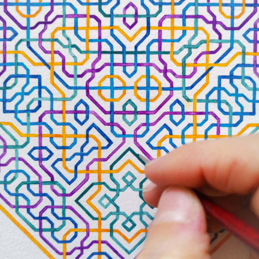 Geometric Pattern 桌布 壁紙 — 一隻手在紋理紙上用細線繪製複雜多彩的幾何圖案。