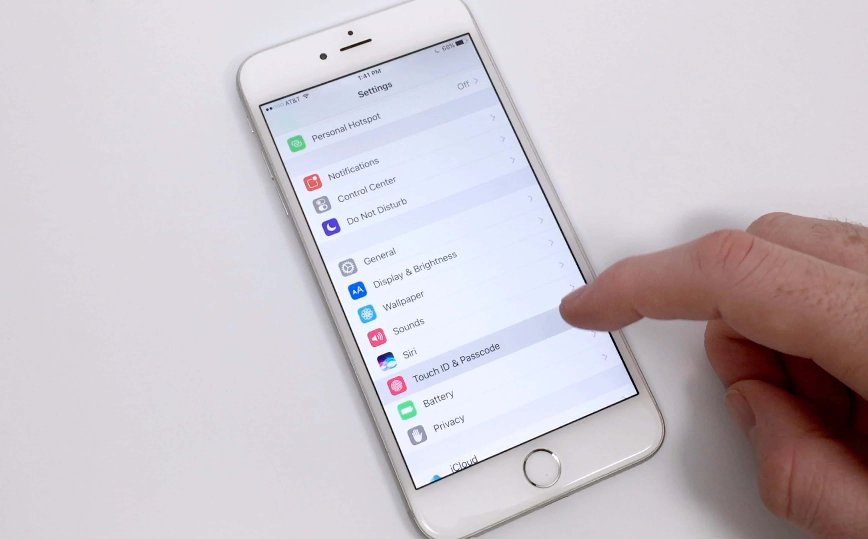 Touch Id 桌布 壁紙 — 一隻手在純白色背景的iPhone設定畫面上點擊桌布選項。