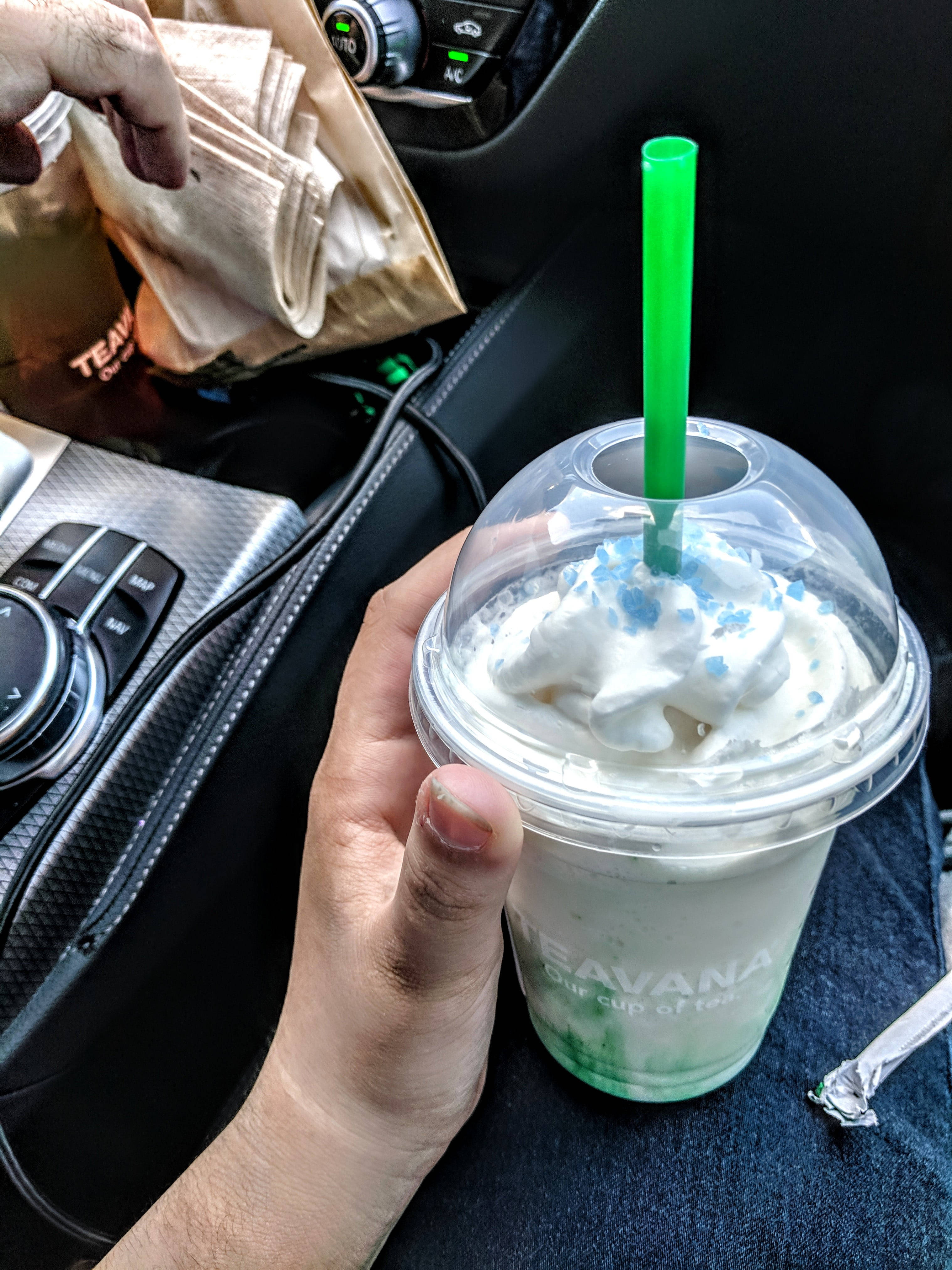 星巴克 桌布 壁紙 — 一隻手在車內拿著一杯有鮮奶油和藍色糖粒的Teavana冰茶飲料。