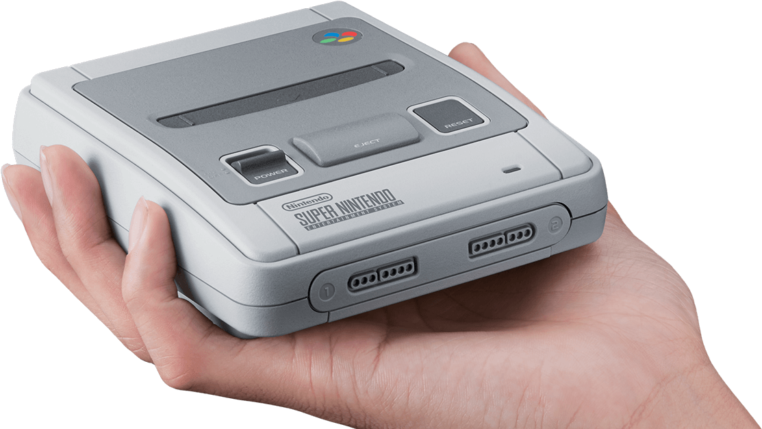 遊戲 桌布 壁紙 — 一隻手在黑色背景前拿著灰色Super Nintendo Entertainment System主機。