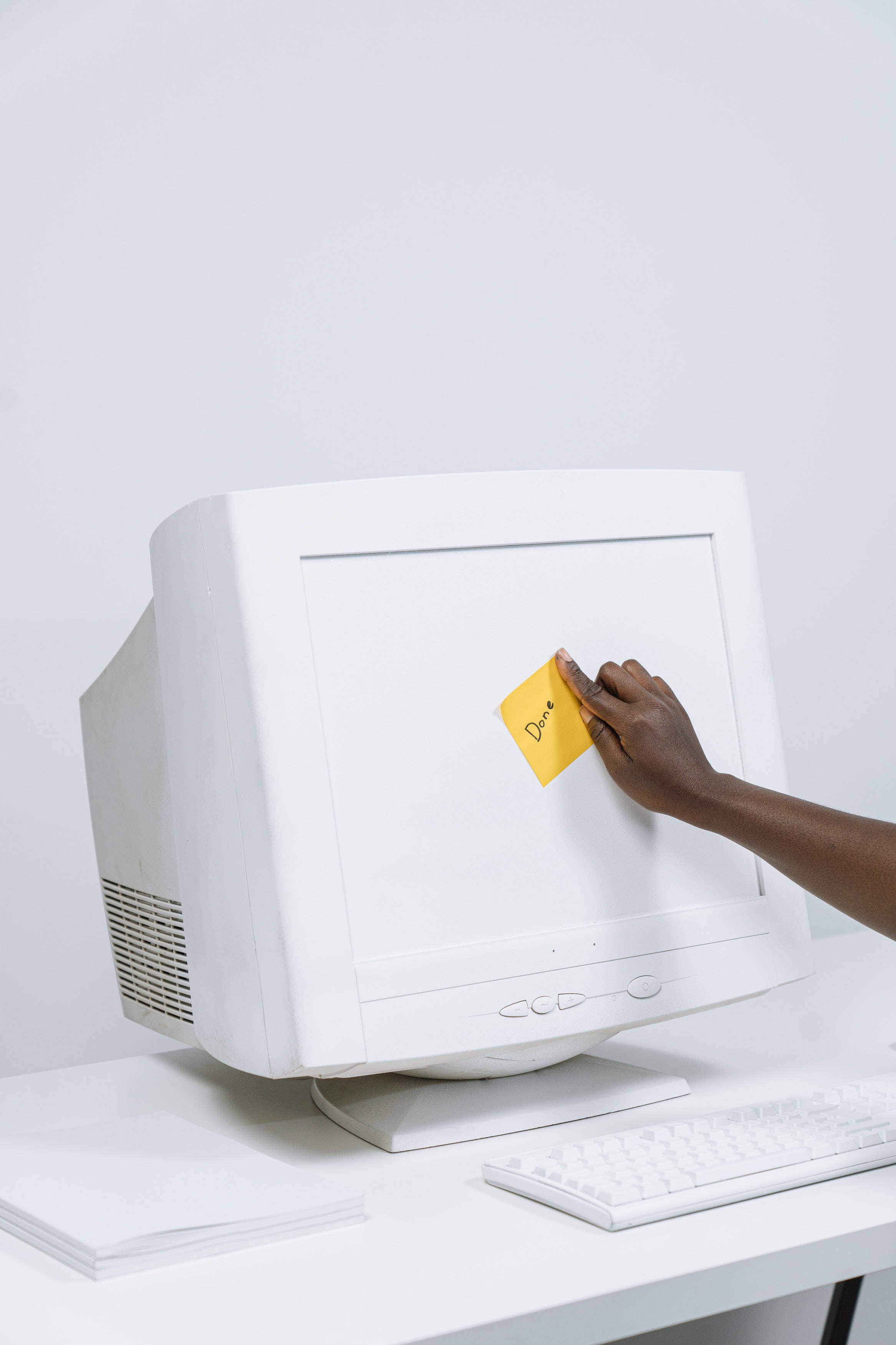Computer Screen 桌布 壁紙 — 一隻手將一張寫有「Done」的黃色便利貼貼在復古白色CRT電腦顯示器的螢幕上。