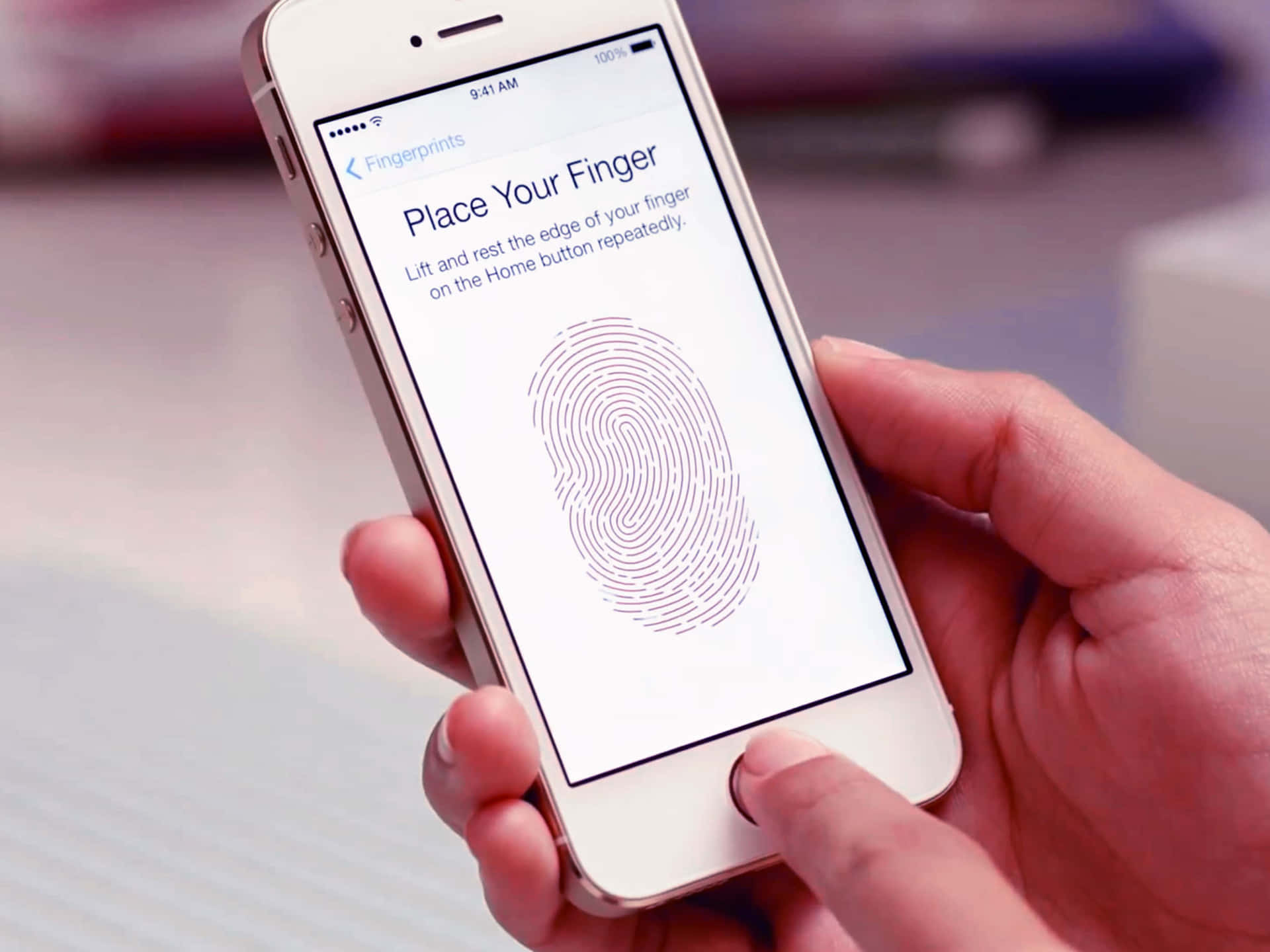 Touch Id 桌布 壁紙 — 一隻手將手指放在 iPhone 的主頁按鈕上，以設定 Touch ID，螢幕上顯示指紋圖形。