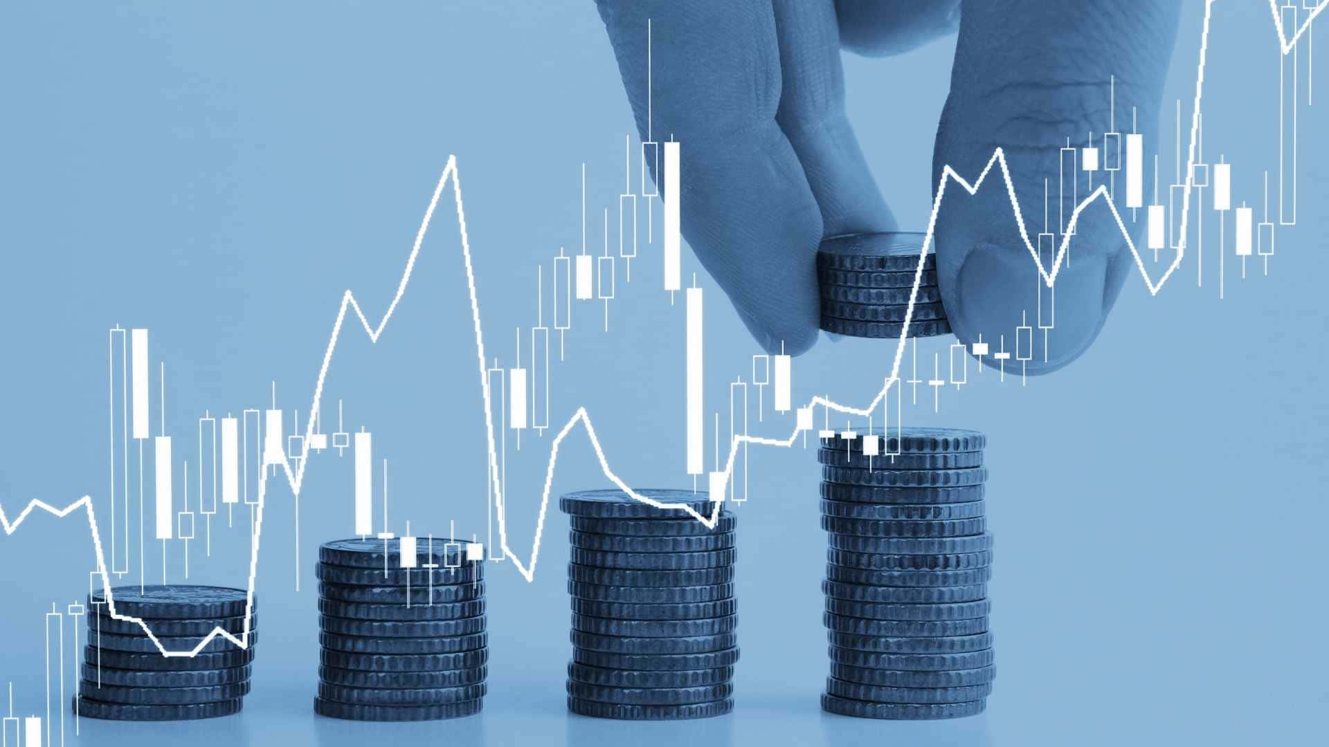 Money 桌布 壁紙 — 一隻手將硬幣放在不斷增長的堆疊上，背景為藍色，並覆蓋白色金融圖表。