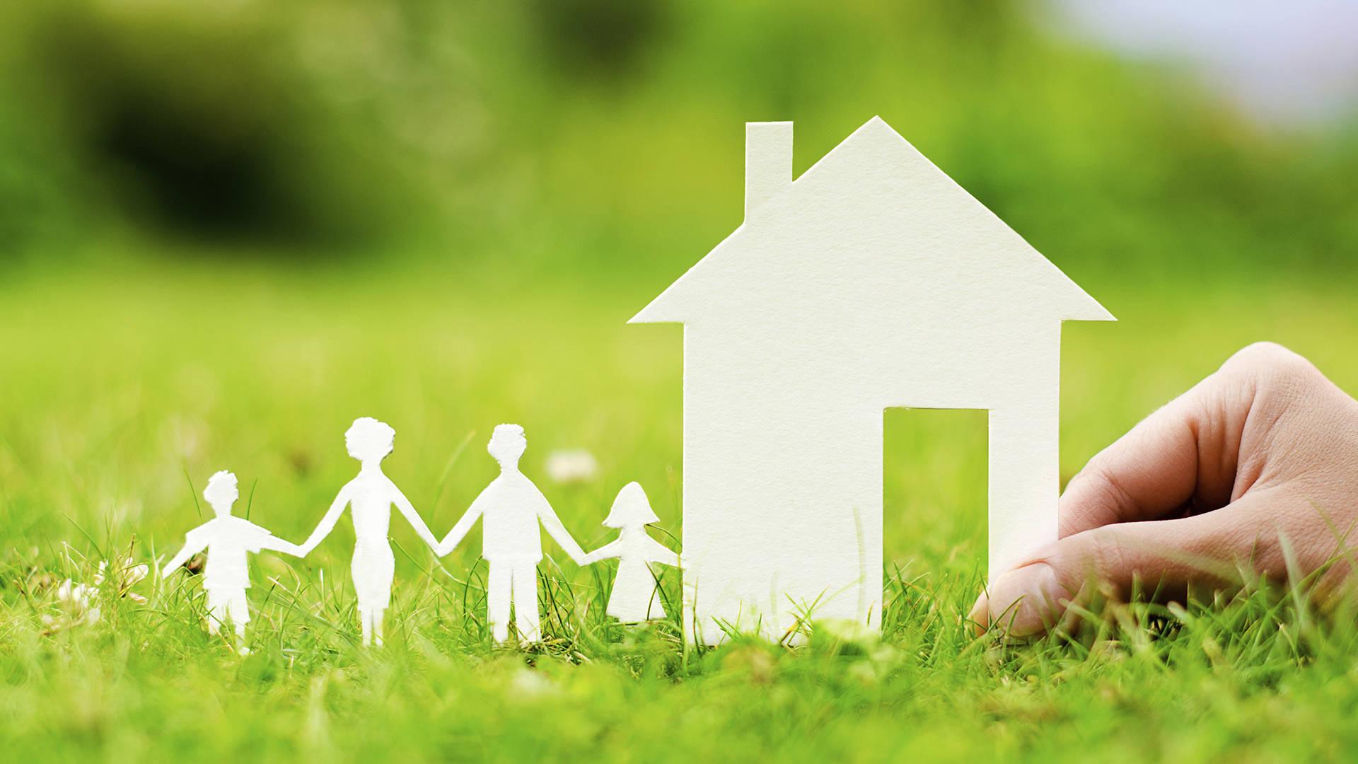 Home 桌布 壁紙 — 一隻手將紙屋放在紙家庭剪紙旁邊，在鮮綠色的草地上。