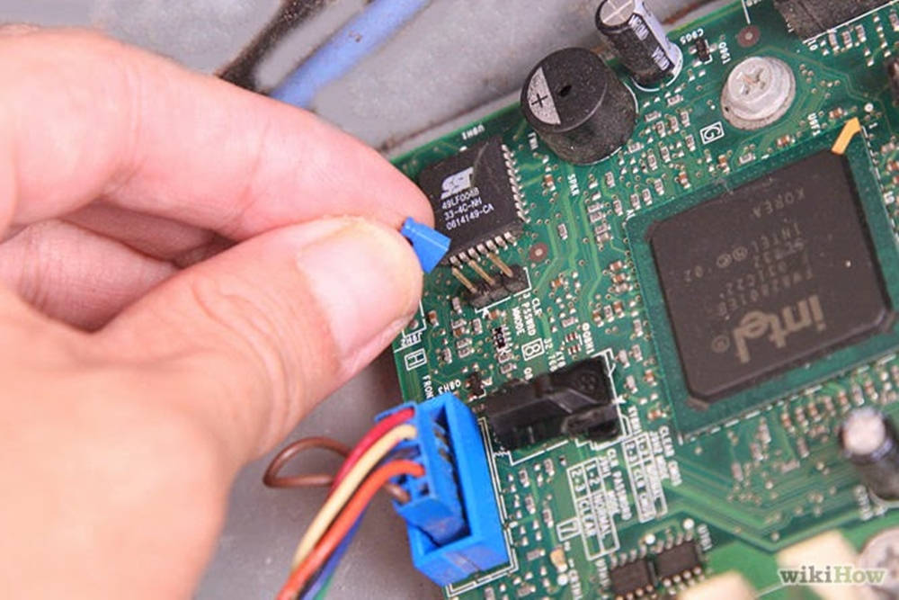Motherboard 桌布 壁紙 — 一隻手小心地將藍色連接器插入帶有Intel晶片和各種電子元件的綠色電路板。