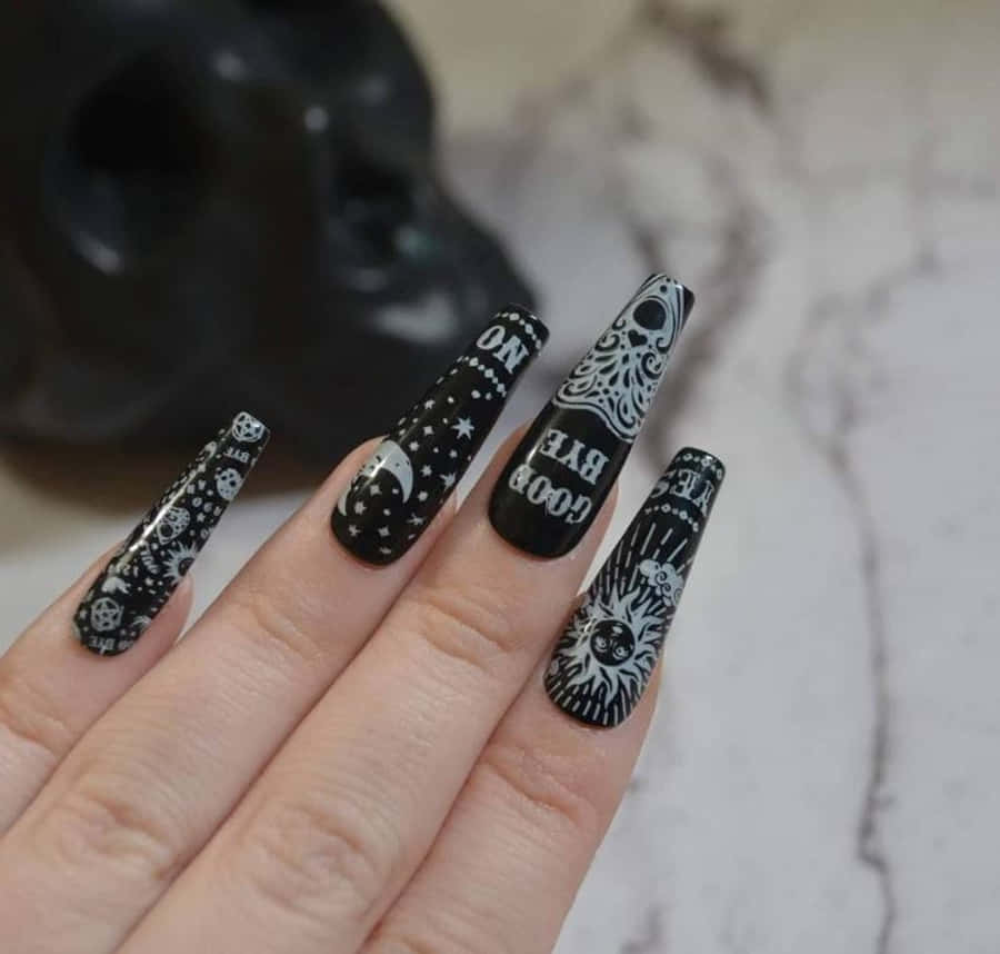 Halloween Nail Art 桌布 壁紙 — 一隻手帶有長黑色棺材指甲，上面有白色天體和骷髏設計，並帶有'good rye'和'no rye'等短語，背景為大理石和骷髏。
