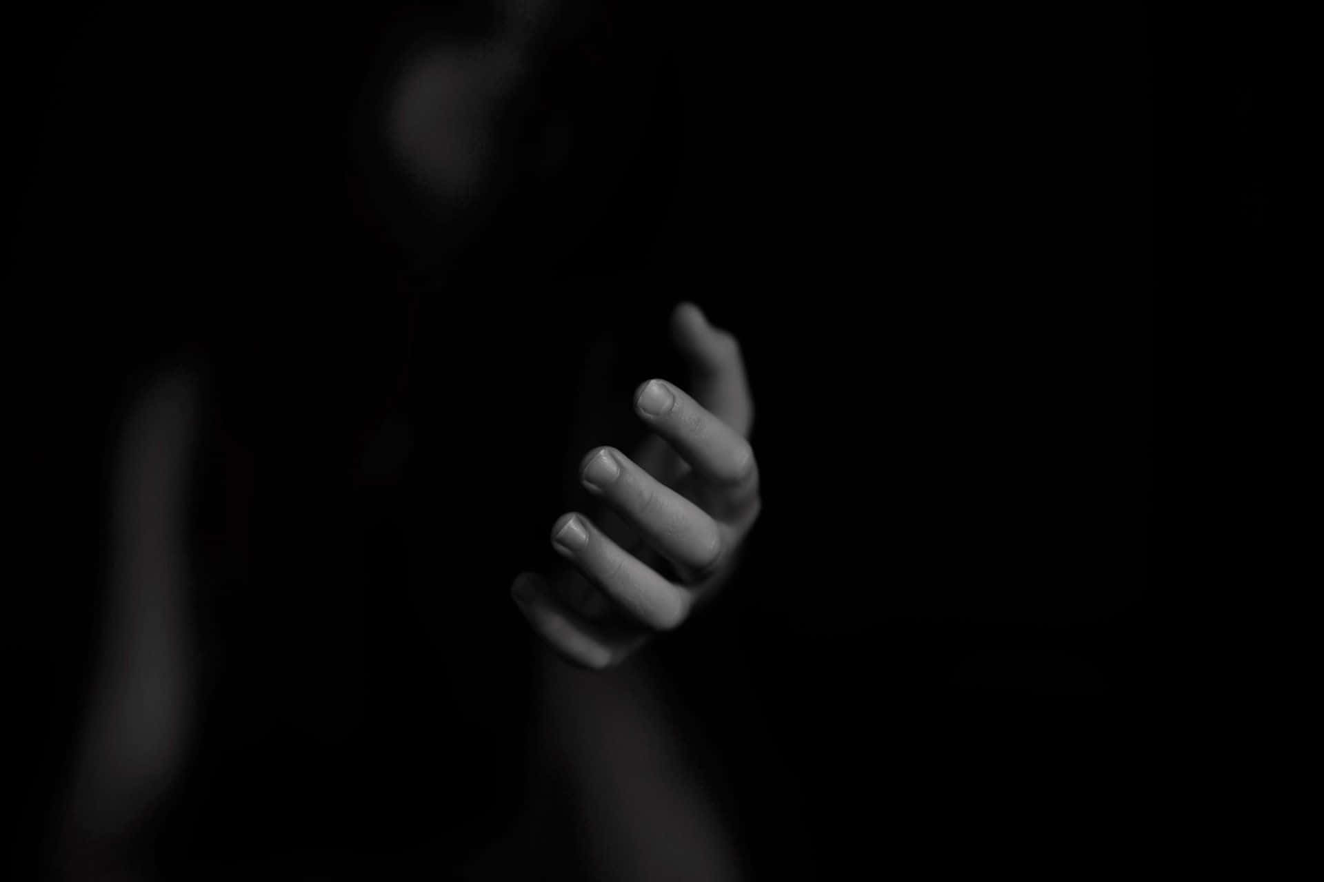 Dark Hand 桌布 壁紙 — 一隻手從黑暗中顯現，呈現鮮明的黑白照片風格，手指微微彎曲，彷彿在伸手或抓取。
