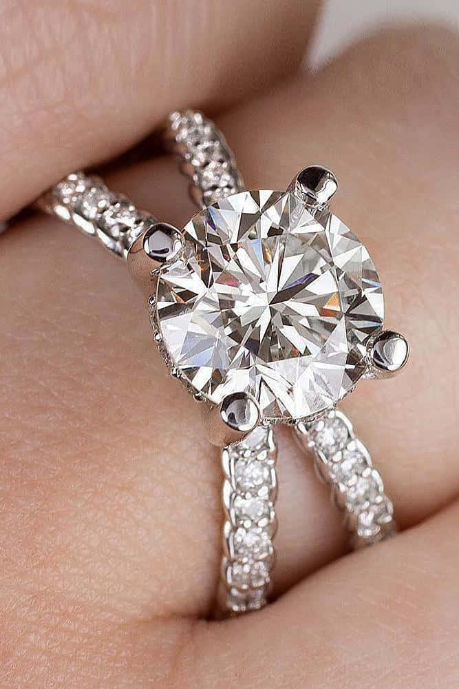 rings 桌布 壁紙 — 一隻手戴著閃爍的鑽石訂婚戒指和相配的鑽石結婚戒指的特寫。