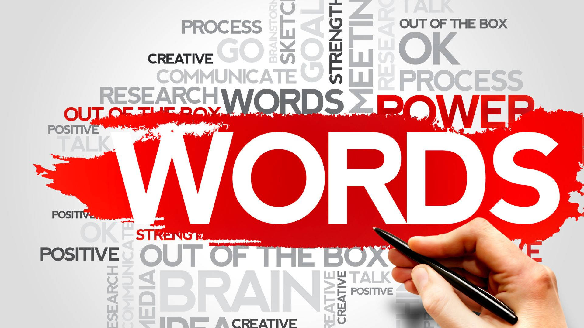 Word 桌布 壁紙 — 一隻手拿著一支筆，放在一個大膽的紅色筆觸上，'WORDS' 這個詞主導了相關激勵術語的背景。