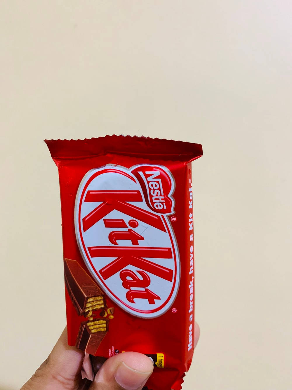手拿著紅色KitKat巧克力棒包裝。 — 食物動圖 壁紙