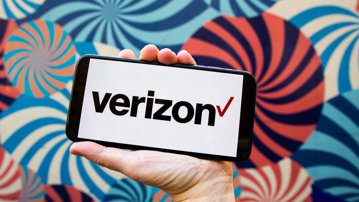 Verizon 桌布 壁紙 — 一隻手拿著一部顯示Verizon標誌的智慧型手機，背景是充滿活力的漩渦圖案牆壁。