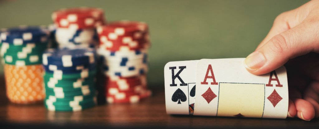 Playing Cards 桌布 壁紙 — 一隻手拿著同花大順的牌，背景是模糊的彩色籌碼堆。