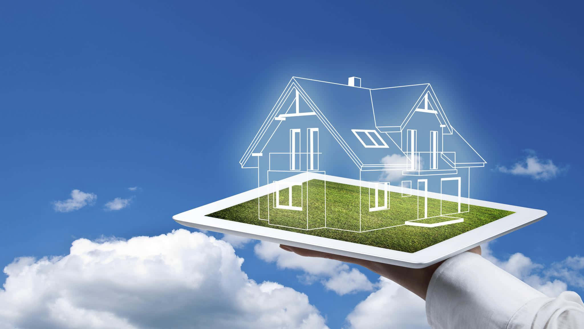 Real Estate Agent 桌布 壁紙 — 一隻手拿著平板電腦，顯示一個發光的房屋藍圖漂浮在草地上方，背景是明亮的藍天和蓬鬆的白雲。