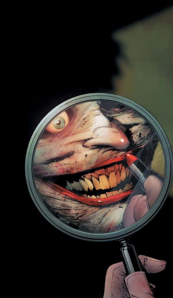 Batman The New 52 桌布 壁紙 — 一隻手拿著放大鏡，在黑暗背景上揭示一個帶有紅唇和黃牙的怪誕咧嘴笑臉。