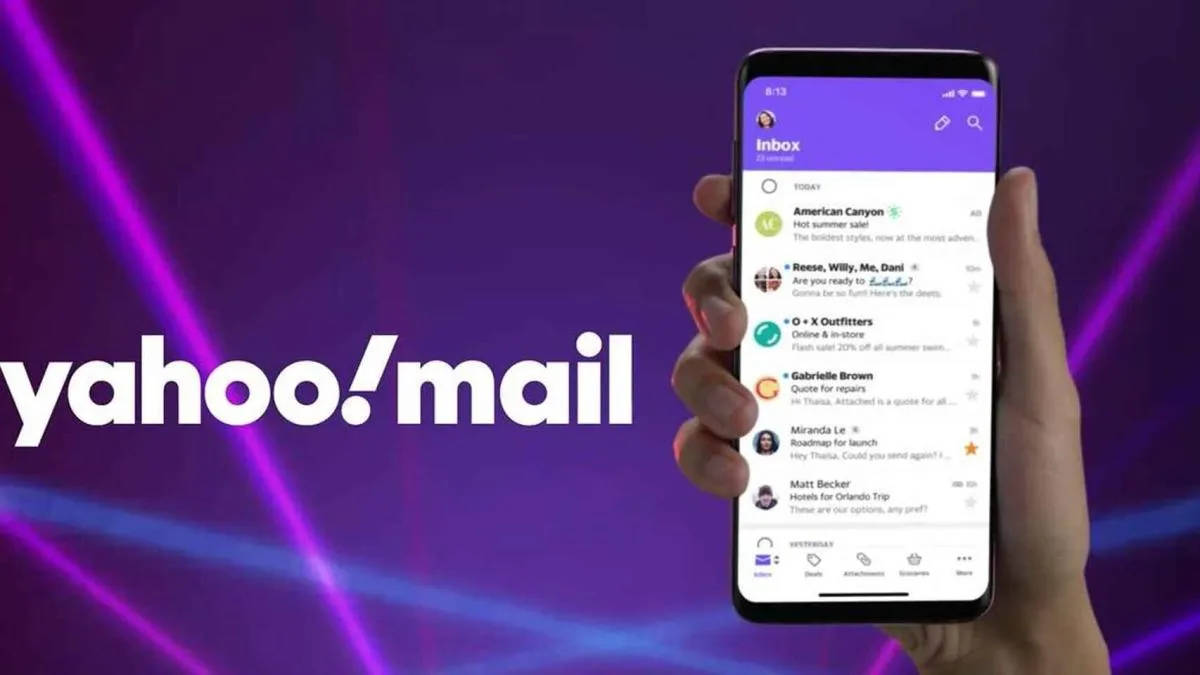 Yahoo Mail 桌布 壁紙 — 一隻手拿著智慧型手機，顯示 Yahoo Mail 收件匣，背景是充滿活力的紫色霓虹燈光，帶有發光的燈光條紋。