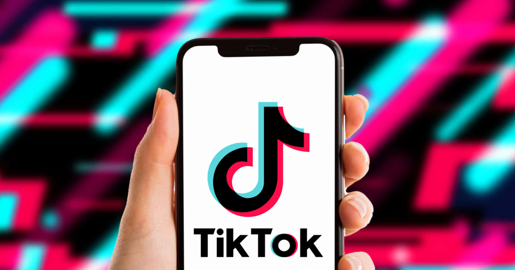 TikTok 動圖 桌布 壁紙 — 一隻手拿著智慧型手機，顯示TikTok標誌，背景是充滿活力的霓虹抽象圖案。