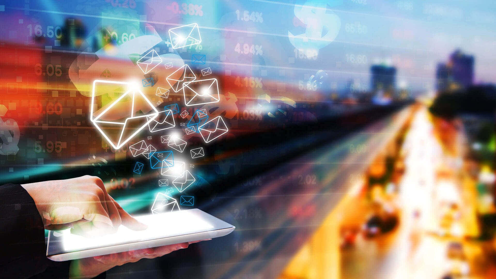 Email 桌布 壁紙 — 一隻手拿著發光的平板電腦，數位郵件圖示和財務數據在黃昏時分模糊的城市景觀上方漂浮。