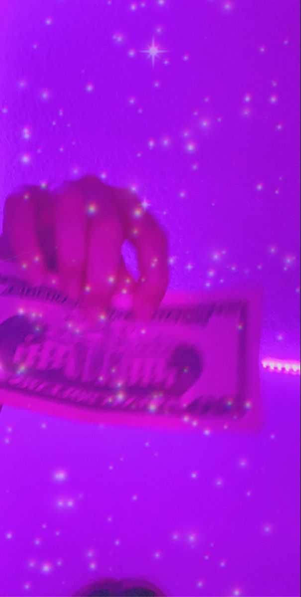 Purple Baddie 桌布 壁紙 — 一隻手拿著發光的粉紅色糖果棒，背景是閃爍的紫色星空。