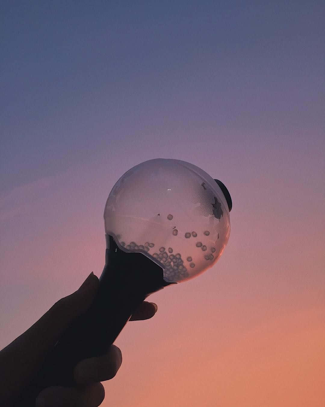 Bts Army Bomb 桌布 壁紙 — 一隻手拿著透明泡泡棒，對著塗上柔和粉紅和紫色調的暮色天空。