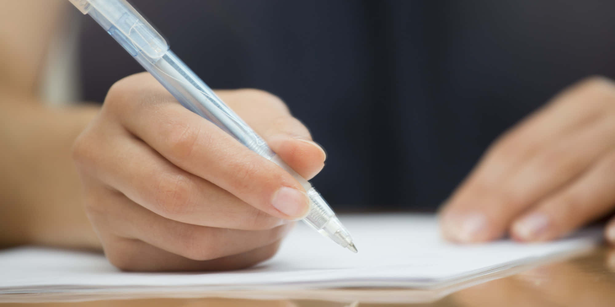 paper 桌布 壁紙 — 一隻手拿著透明筆準備在白色紙上寫字的特寫。