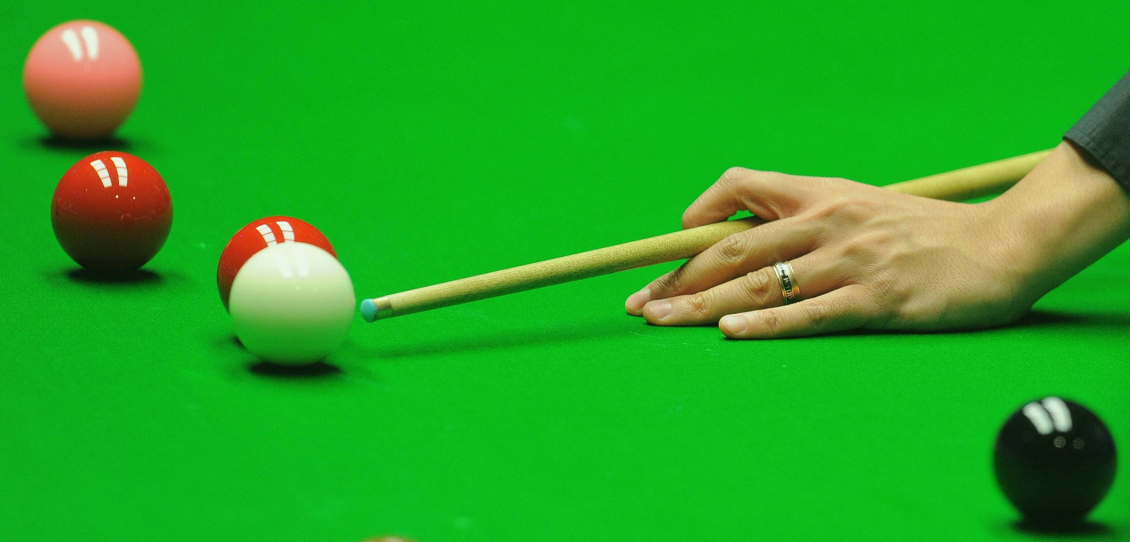 Snooker 桌布 壁紙 — 一隻手握住球桿準備擊打綠色絨布桌面上白色撞球的近距離特寫。