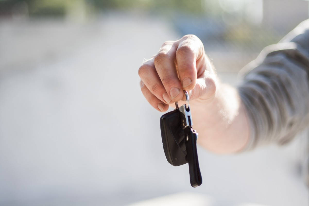 Purchase 桌布 壁紙 — 一隻手握住車鑰匙，背景明亮而模糊，暗示新的開始或離去。