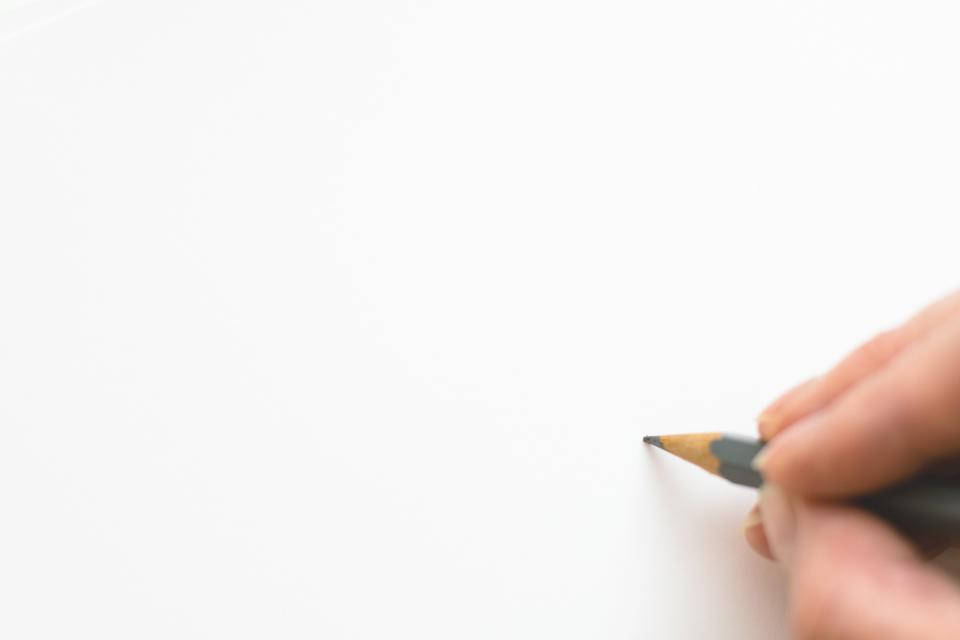pencil 桌布 壁紙 — 一隻手握著石墨鉛筆，準備在空白的白紙上畫畫。