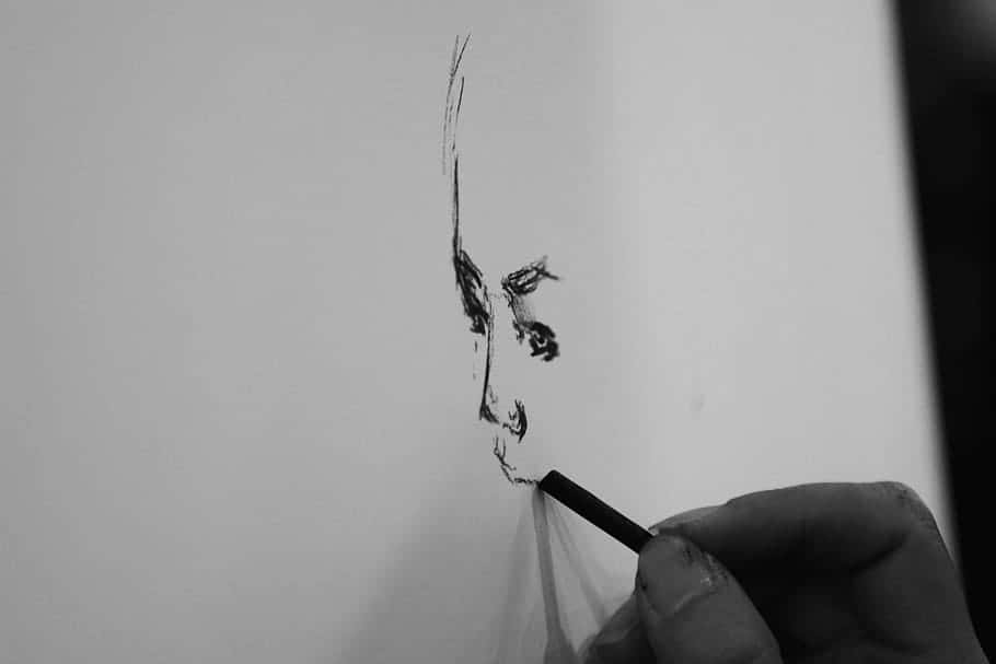 Charcoal Drawings 桌布 壁紙 — 一隻手正在白紙上用大膽而富有表現力的單色筆觸勾勒出強烈的炭筆肖像。