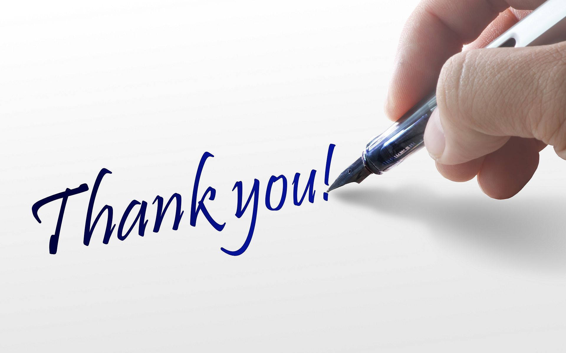 Thanks 桌布 壁紙 — 一隻手用鋼筆在潔白紙上以優雅的藍色草書寫下「謝謝！」