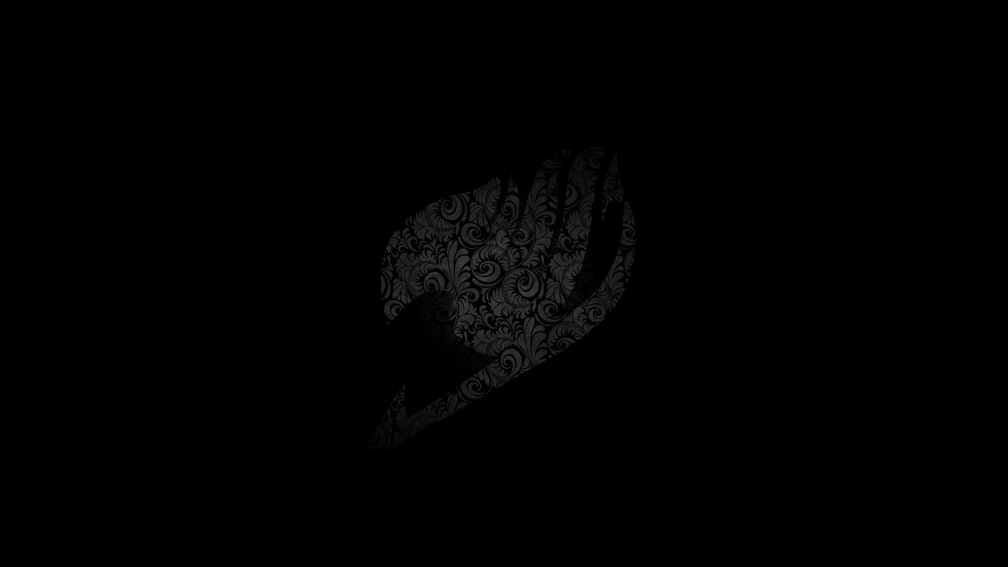 Fairy Tail Logo 桌布 壁紙 — 一隻手的深色剪影，帶有複雜的漩渦圖案，在黑色背景上微弱發光。