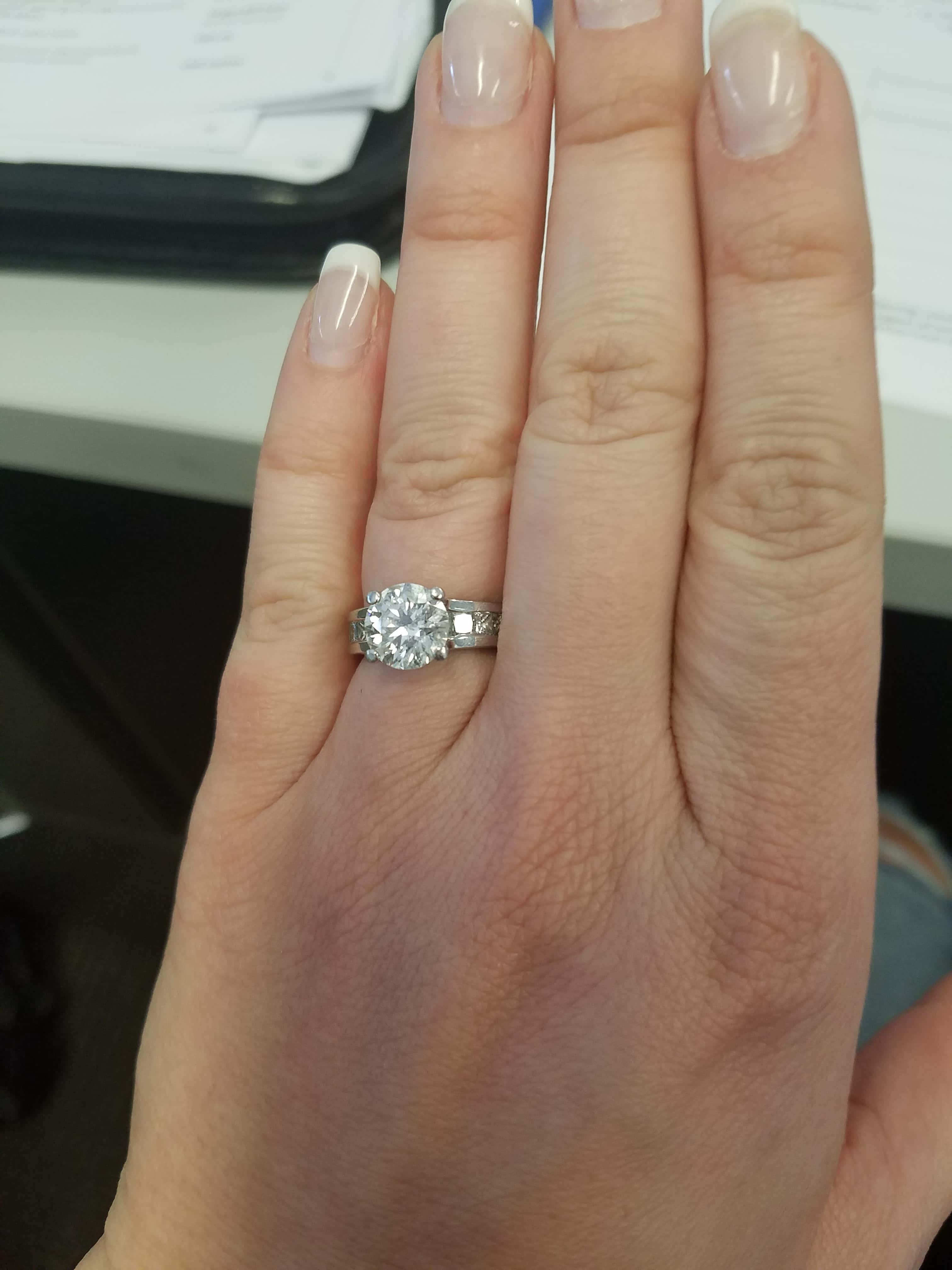 rings 桌布 壁紙 — 一隻手的特寫，無名指上戴著閃爍的鑽石訂婚戒指。